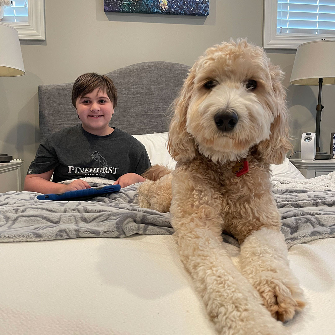 Alex and Olive sitting together on a bed